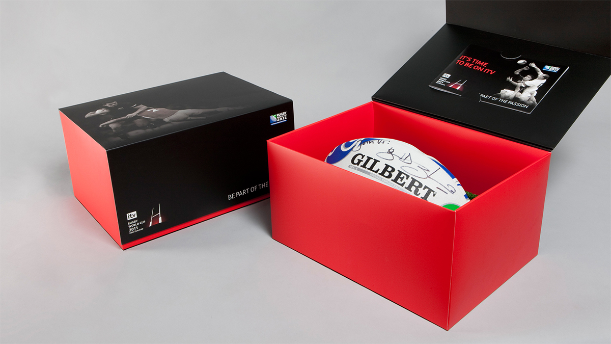Image of the Rugby World Cup direct mail campaign with a signed rugby ball inside a box. Earnie creative design